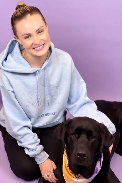 Molly is wearing her classic pets blue hoodie and sitting with her beautiful guide dog 